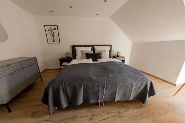 Großes Schlafzimmer mit Boxspringbett und Arbeitsplatz - BONNYSTAY