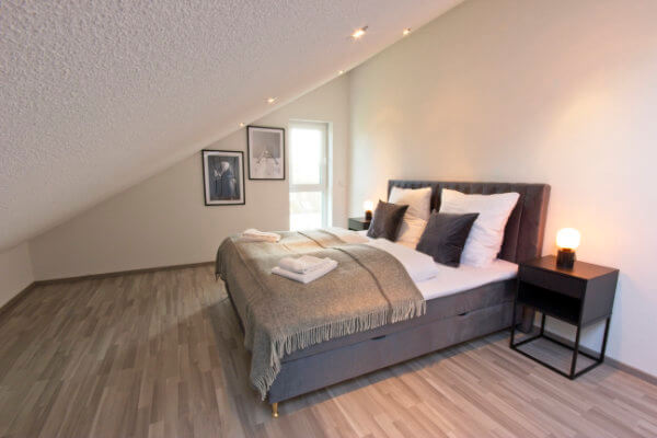 Bedroom with bed linen and extra pillows and blankets