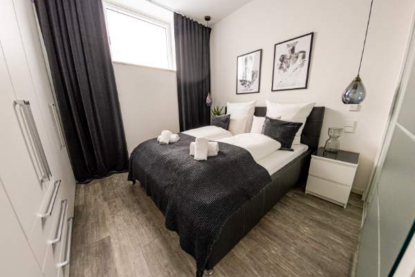 Schlafzimmer mit Doppelbett und Bettwäsche - BONNYSTAY