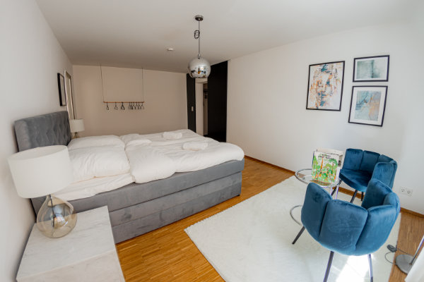 Bedroom with box spring bed, bed linen and towels